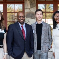 Quincy Williams poses with 3 other people outside Alumni House